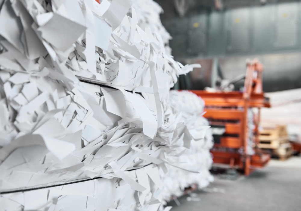 A paper recycling factory plant shredding machine, shredding waste paper into square bails. Ready to be pulped and reused.