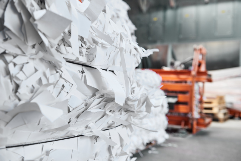 A paper recycling factory plant shredding machine, shredding waste paper into square bails. Ready to be pulped and reused.