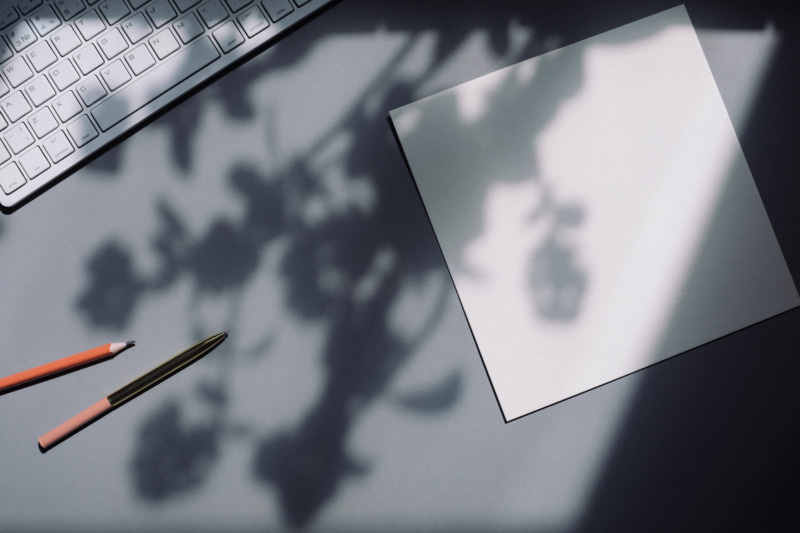 Stylish workspace with laptop, empty white paper mock up, pen, keyboard.