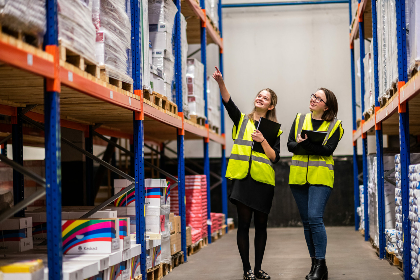 Two warehouse team members pointing to the paper